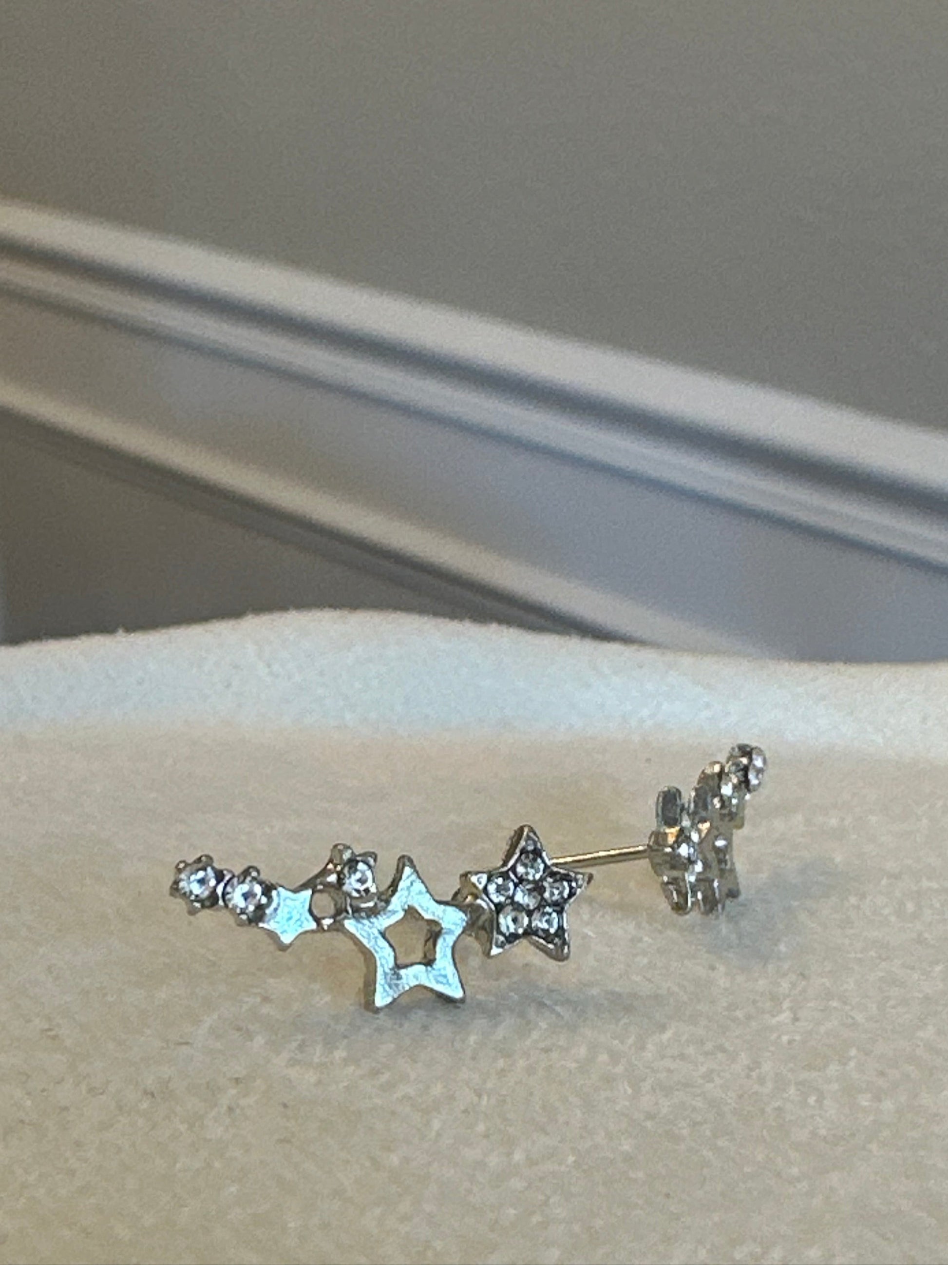 Star-shaped earring on a beige background