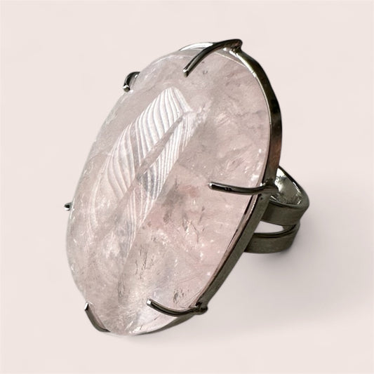 Ring with a large, textured stone and metallic band on a light background