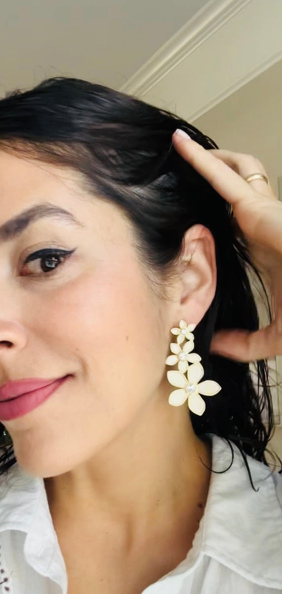 Woman wearing a floral earring with a neutral background