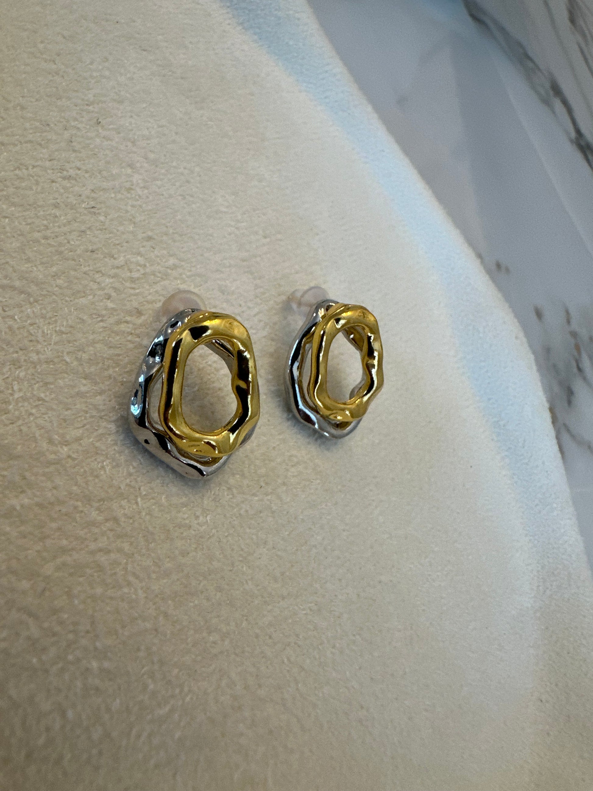 Gold hoop earrings on a marble surface