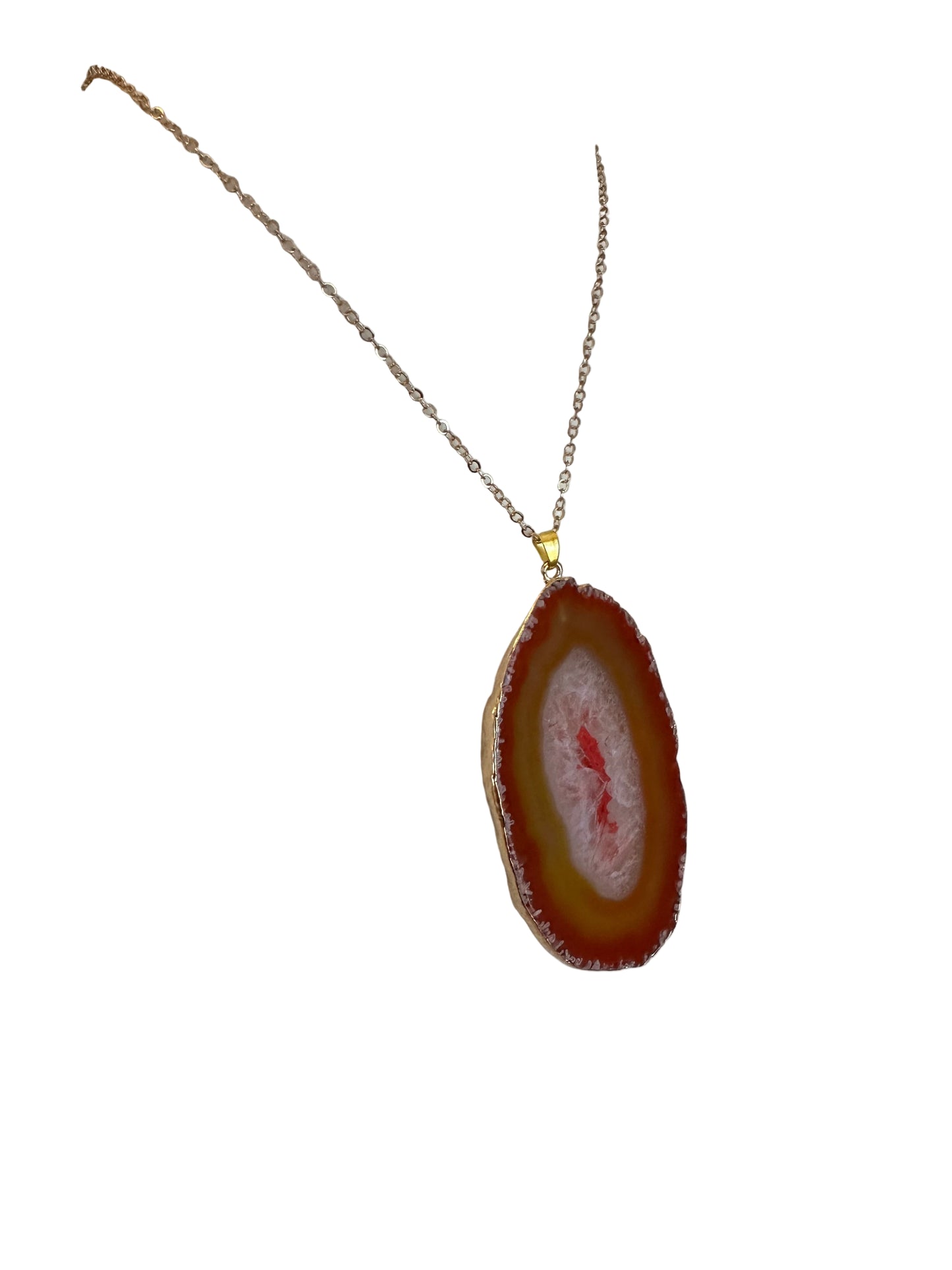 Necklace with a red agate pendant on a white stand.