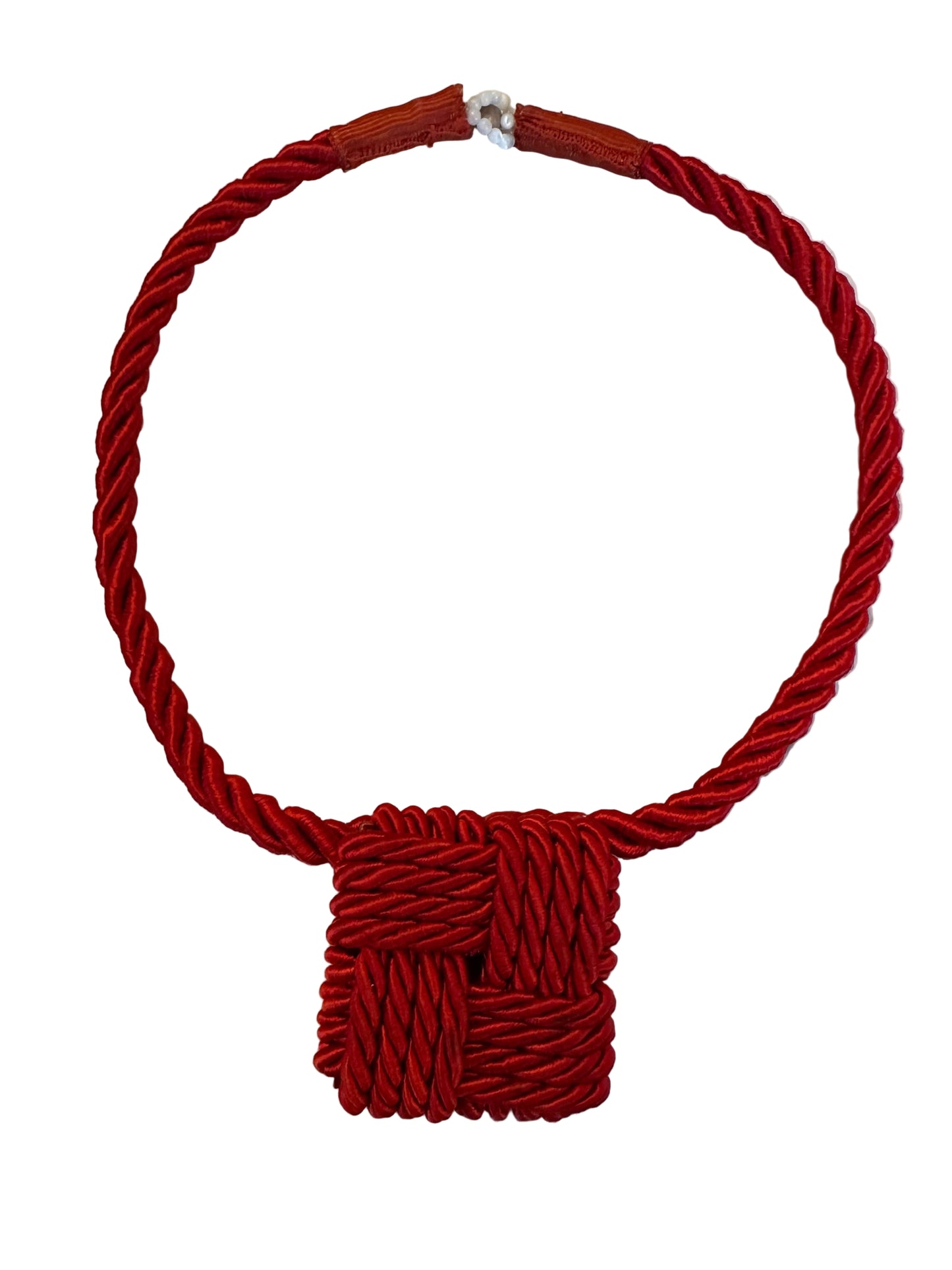 Red braided hair tie on a marble surface