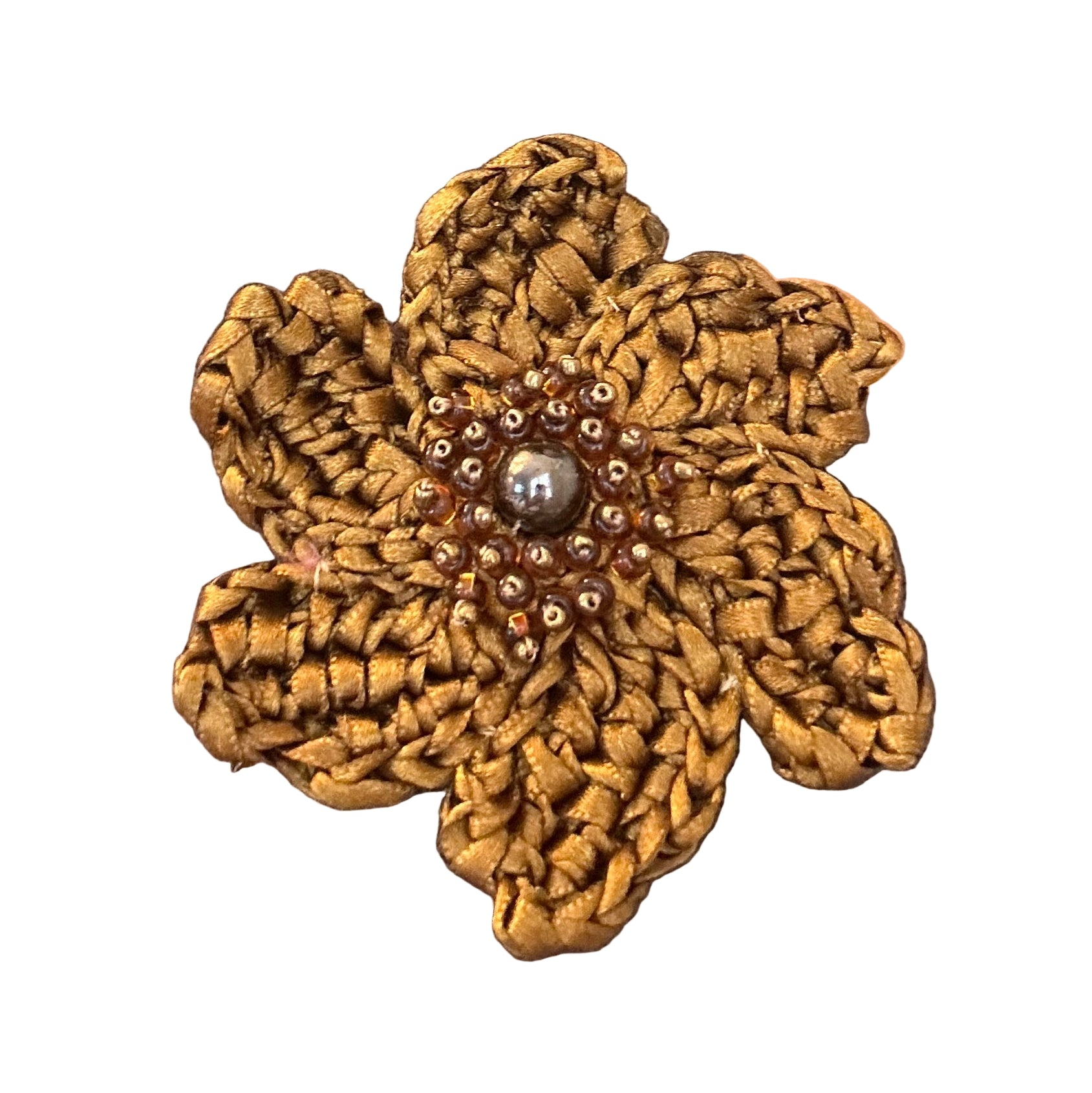Brown top with a decorative gold flower brooch on a wooden floor.