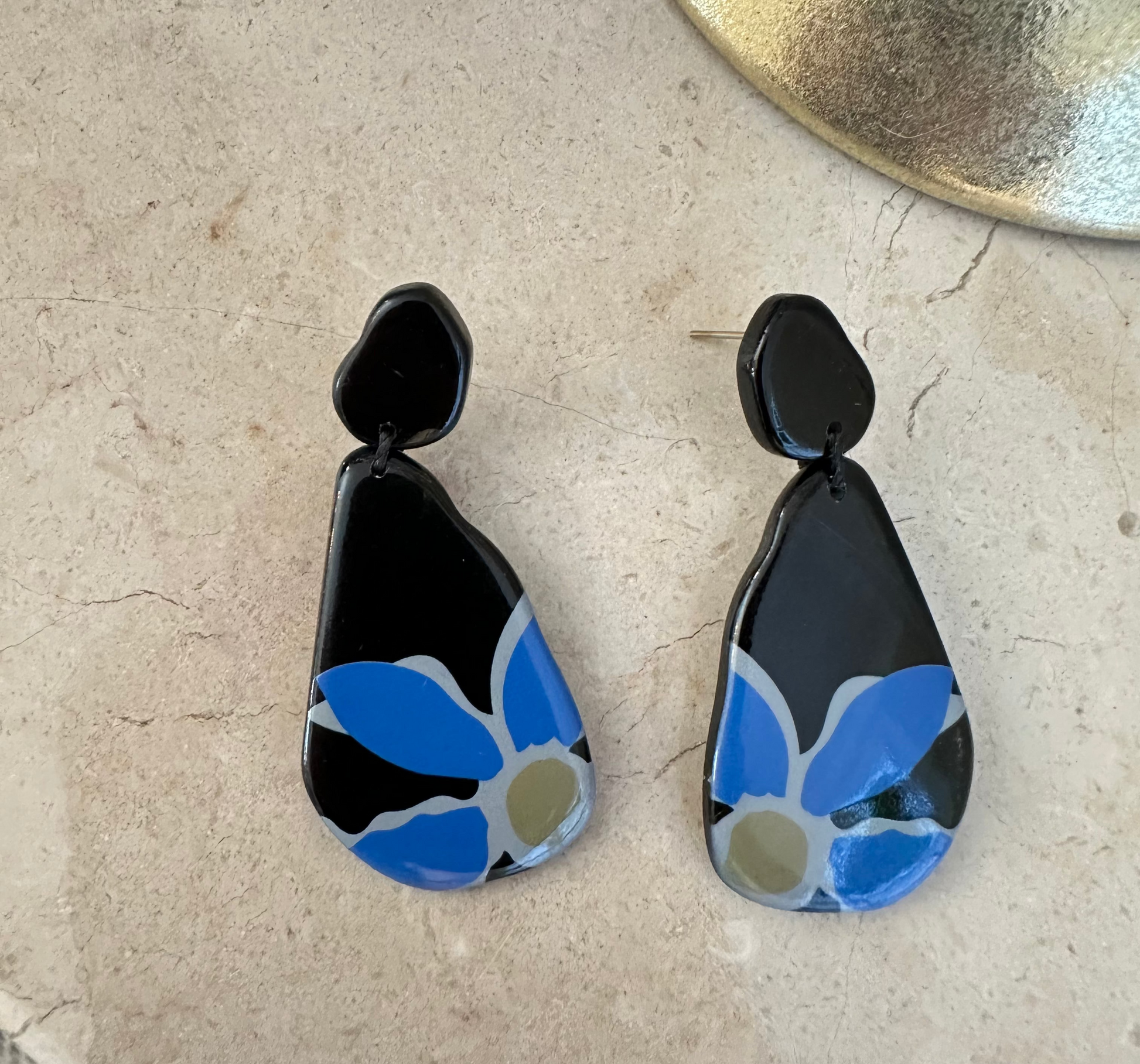 Black and blue earrings on a textured surface