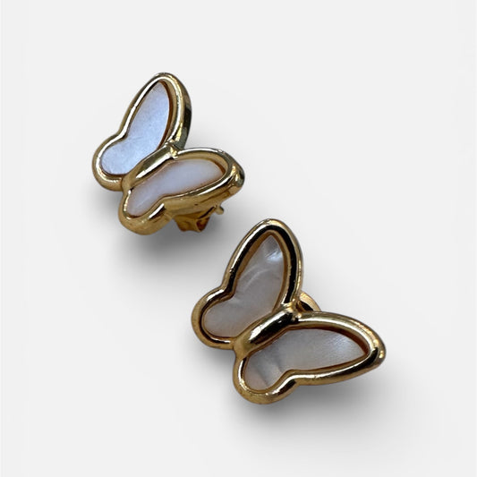 Butterfly-shaped earrings with gold frame and light blue center on a white background