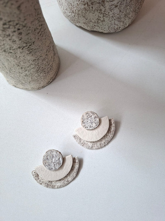 Pair of earrings with geometric design on a light surface